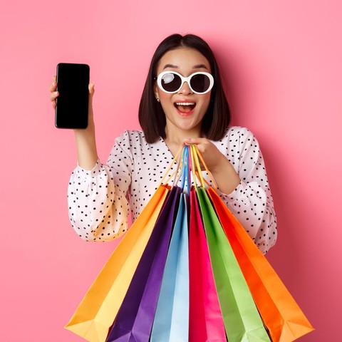 Wanita membawa banyak kantong belanja warna-warni setelah mendapatkan harga murah untuk produk berkualitas